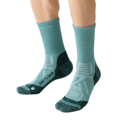 Green Merino wool hiking socks worn on foot, showing the crew height, supportive fit, and reinforced toe and heel.