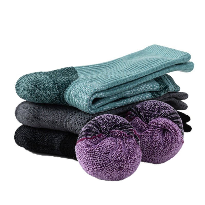 Merino wool hiking socks folded and rolled to display the thick terry cushioning inside the footbed.